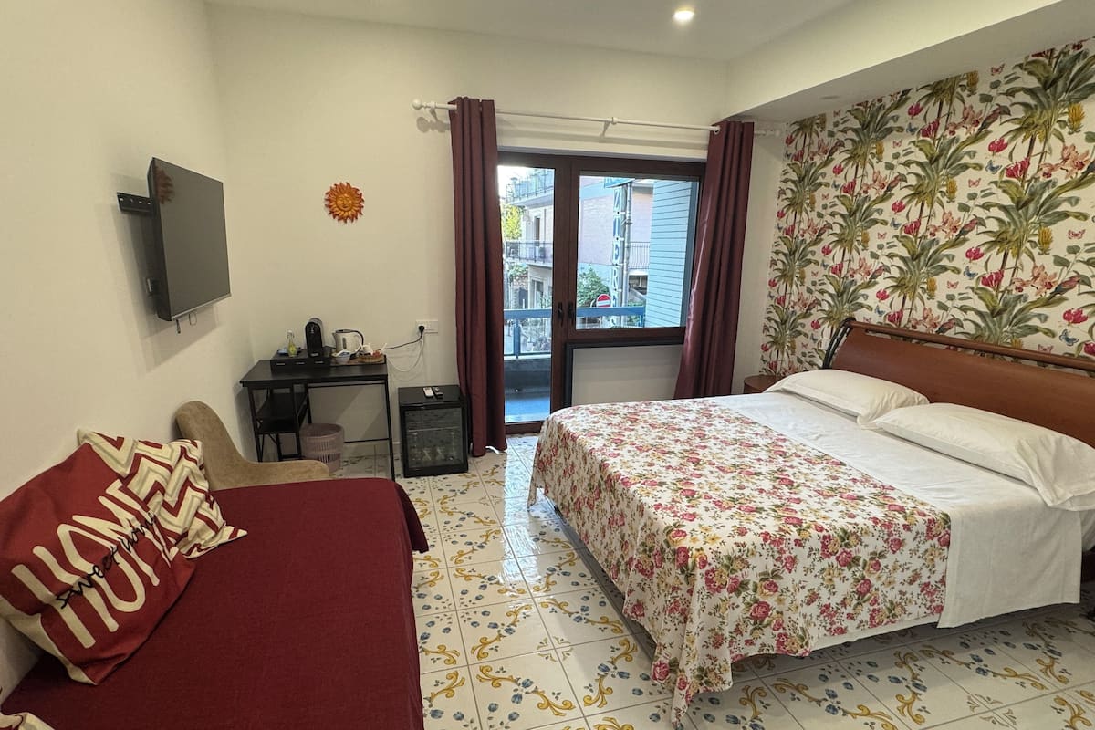 Une chambre à coucher avec un lit, un bureau et une télévision.