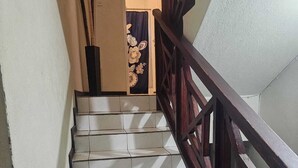 Eine Treppe mit weißen Fliesen und einem hölzernen Geländer.