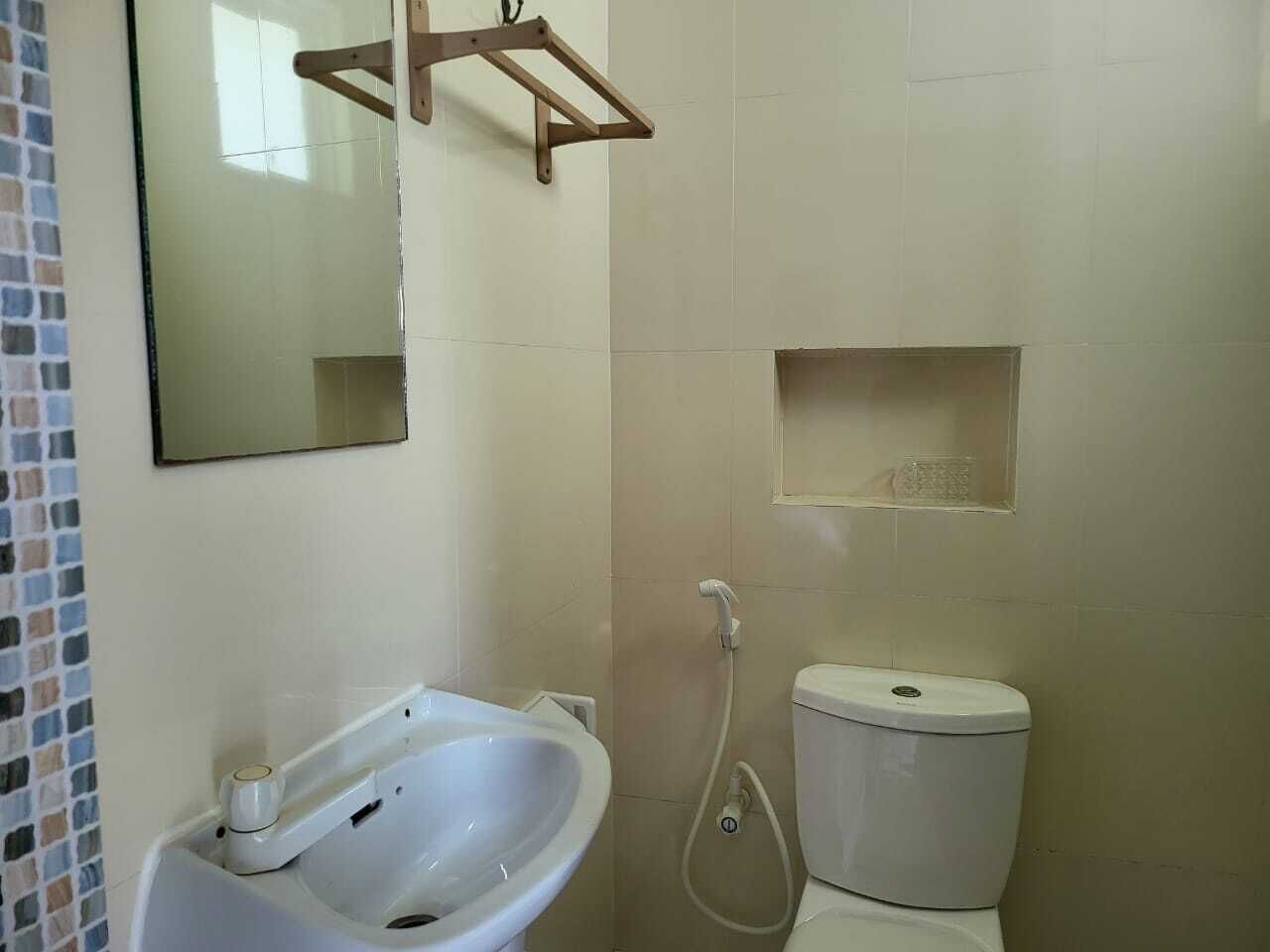 Un baño con lavamanos, espejo y retrete.