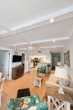 A spacious living area with a kitchen, a dining area, and a seating area with a sofa and a coffee table.