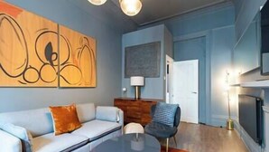 A modern living room with a sofa, a round coffee table, and a blue chair.