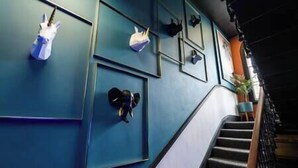 Eine Treppe mit blauer Wand und gerahmten Bildern.