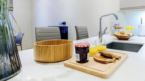 Eine moderne Küche mit einer Holtschale, einem Marmeladenglas und Toast auf einem Schneidebrett.