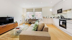 A modern apartment with a living room, dining area, and kitchen. - PBC | Luxury One Bedroom Apartment in Soho GT13 (London)