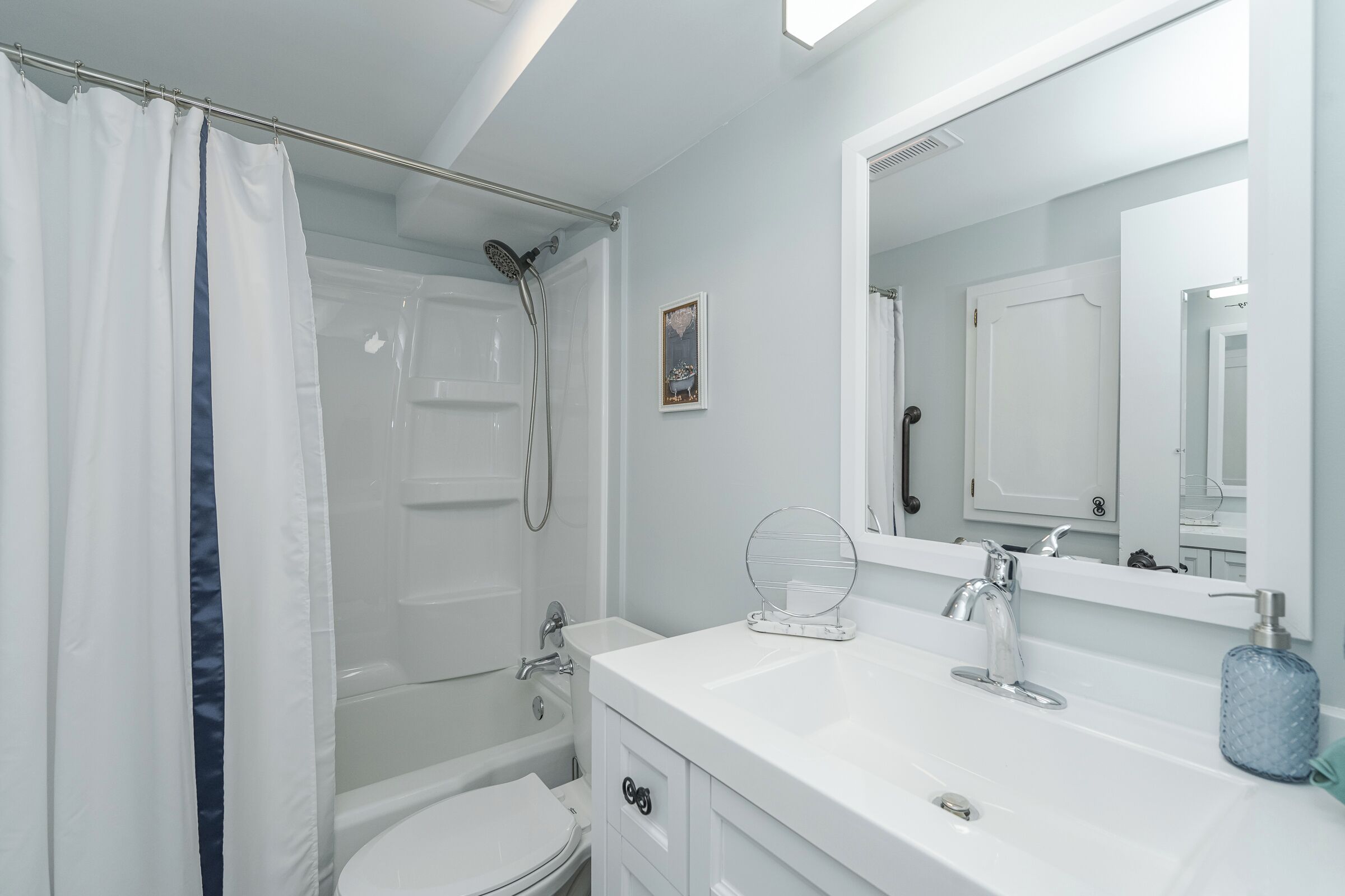 A modern bathroom with a shower, toilet, and sink.
