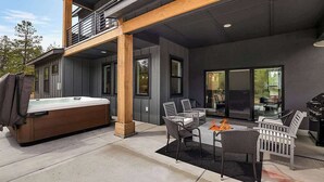 Une terrasse extérieure moderne dotée d’un jacuzzi, d’un espace salon et d’un barbecue.