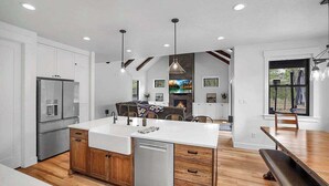 Une cuisine moderne dotée d’un îlot central, de meubles en bois et d’appareils électroménagers en acier inoxydable.