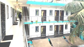 Un immeuble à plusieurs niveaux doté d’un atrium central, de balcons et d’un espace extérieur couvert.