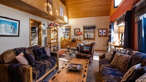 A cozy living room with wooden furniture, a coffee table, and a fireplace. - Charming 3-bedroom cabin with WiFi in Angel Fire (Angel Fire)