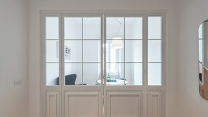 A room with a large sliding glass door leading to a dining area with a table and chairs.