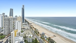 Eine Küstenstadt mit Hochhäusern, einem Sandstrand und blauem Himmel.