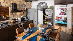 Une cuisine moderne avec des meubles de couleur bois foncé, un four à micro-ondes encastré et un mur en pierre en arrière-plan.