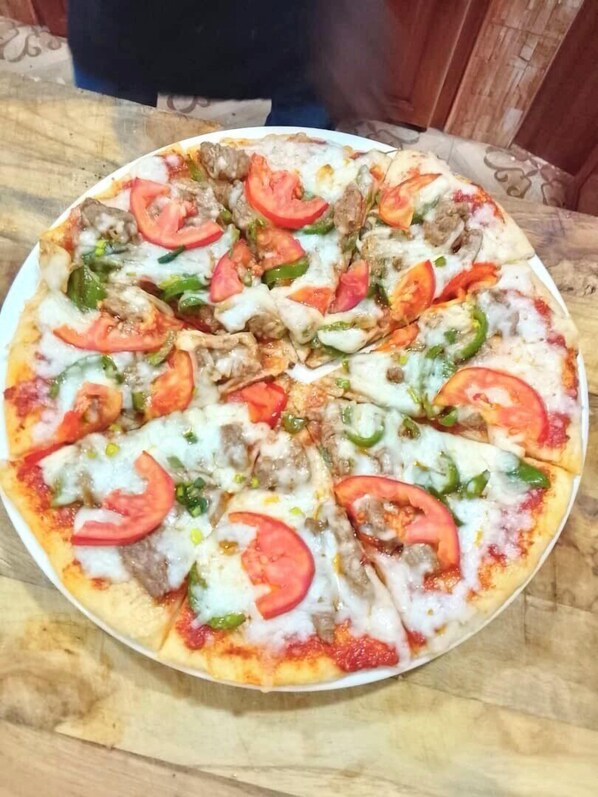A pizza with various toppings on a wooden table.