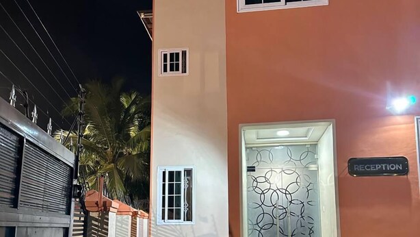 A building with a reception area, a staircase leading to the entrance, and a paved driveway. - Senalli Hotel (Koforidua)