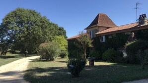 A house with a tiled roof, surrounded by greenery and a gravel path. - Pigeonnier du Rau - GAMARDE LES BAINS (GAMARDE-LES-BAINS)