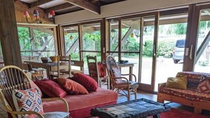 Una habitación acogedora con muebles de mimbre, un sofá rojo y una mesa de centro.