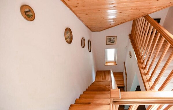 A wooden staircase with a sloped ceiling and a window at the top.