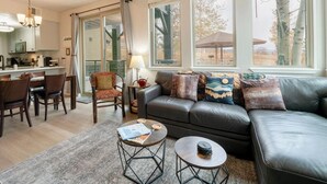A modern living room with a sofa, coffee table, and dining area.