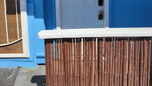 A white door with the letter 'A' above it, a window with a metal grill, and a blue wall with a white trim.