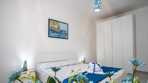 A modern bedroom with a bed, a nightstand, a wardrobe, and a painting on the wall.