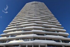 A tall, modern building with a unique, layered architectural design.