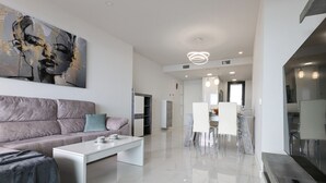 Una sala de estar moderna con sofá, mesa de centro y una obra de arte en la pared.