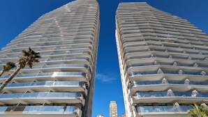 Two tall, modern buildings with a curved facade and numerous balconies. - SUNSET CLIFFS sweet apartment (Benidorm)