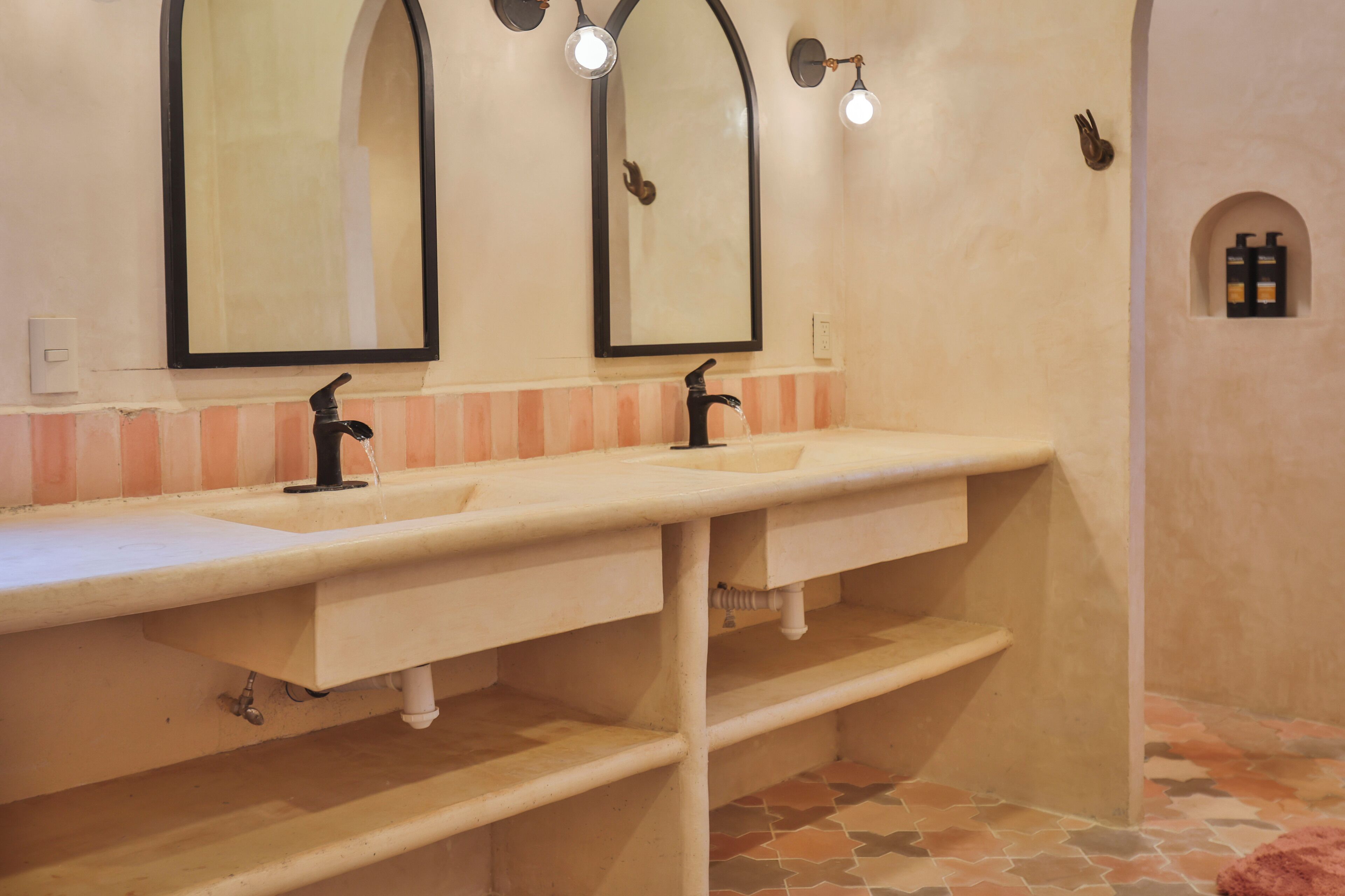A bathroom with two sinks, a mirror, and a tiled floor.