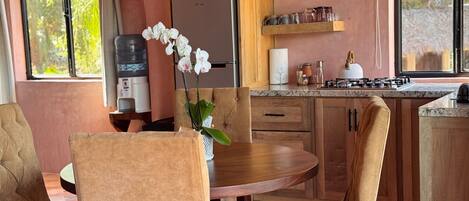 A modern kitchen with wooden cabinets, a round dining table, and chairs.