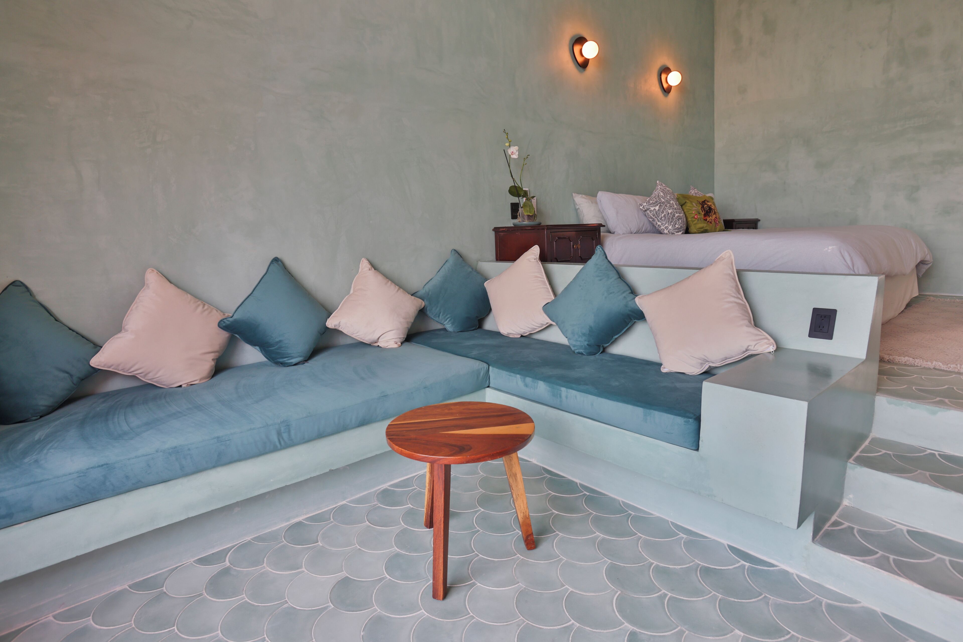 A modern living room with a sectional sofa, a small wooden table, and a decorative vase on a console table.