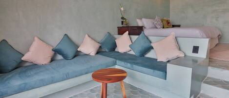A modern living room with a sectional sofa, a small wooden table, and a decorative vase on a console table.