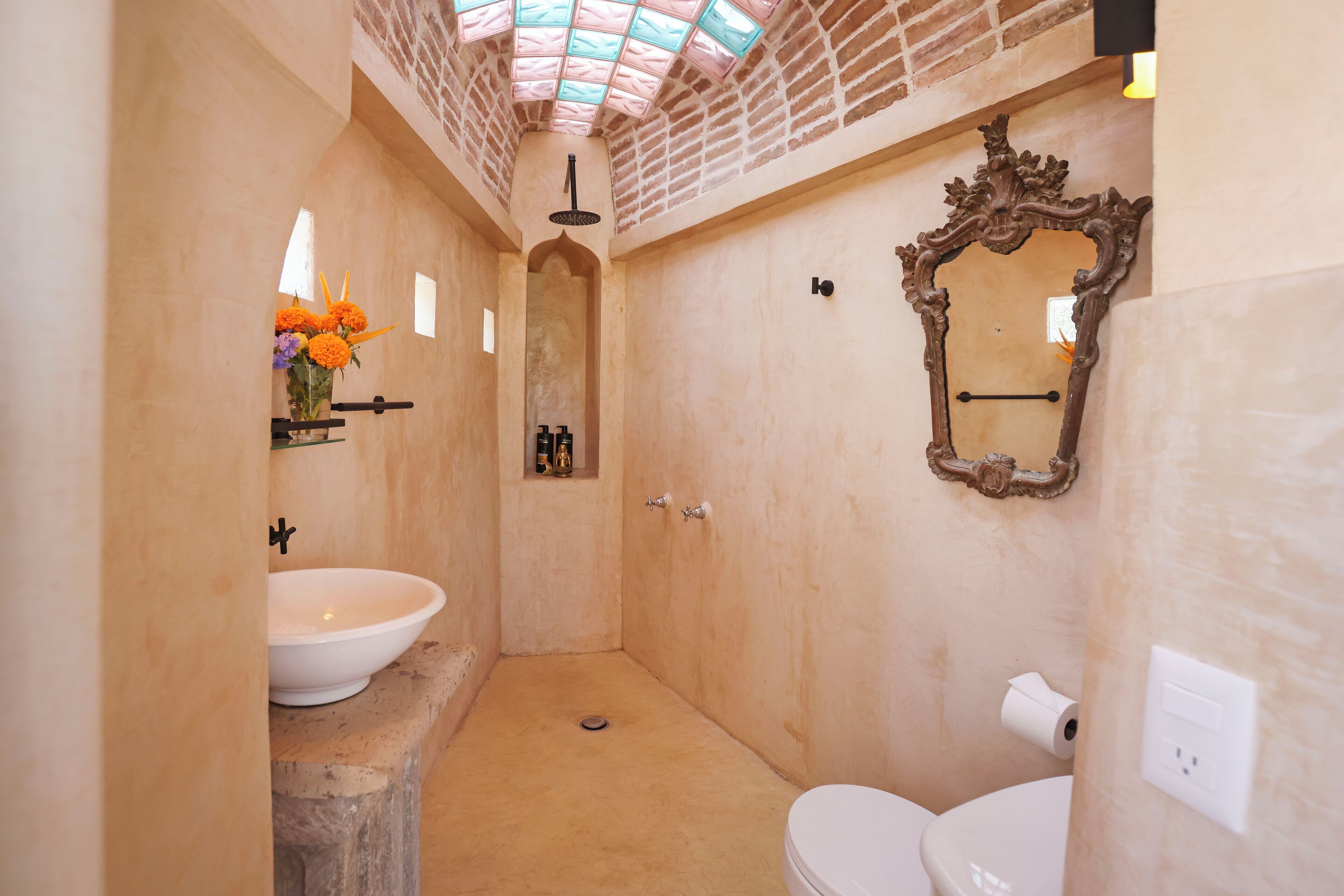 Ein Badezimmer mit einem weißen Waschbecken, einer Toilette und einer Duschkabine.