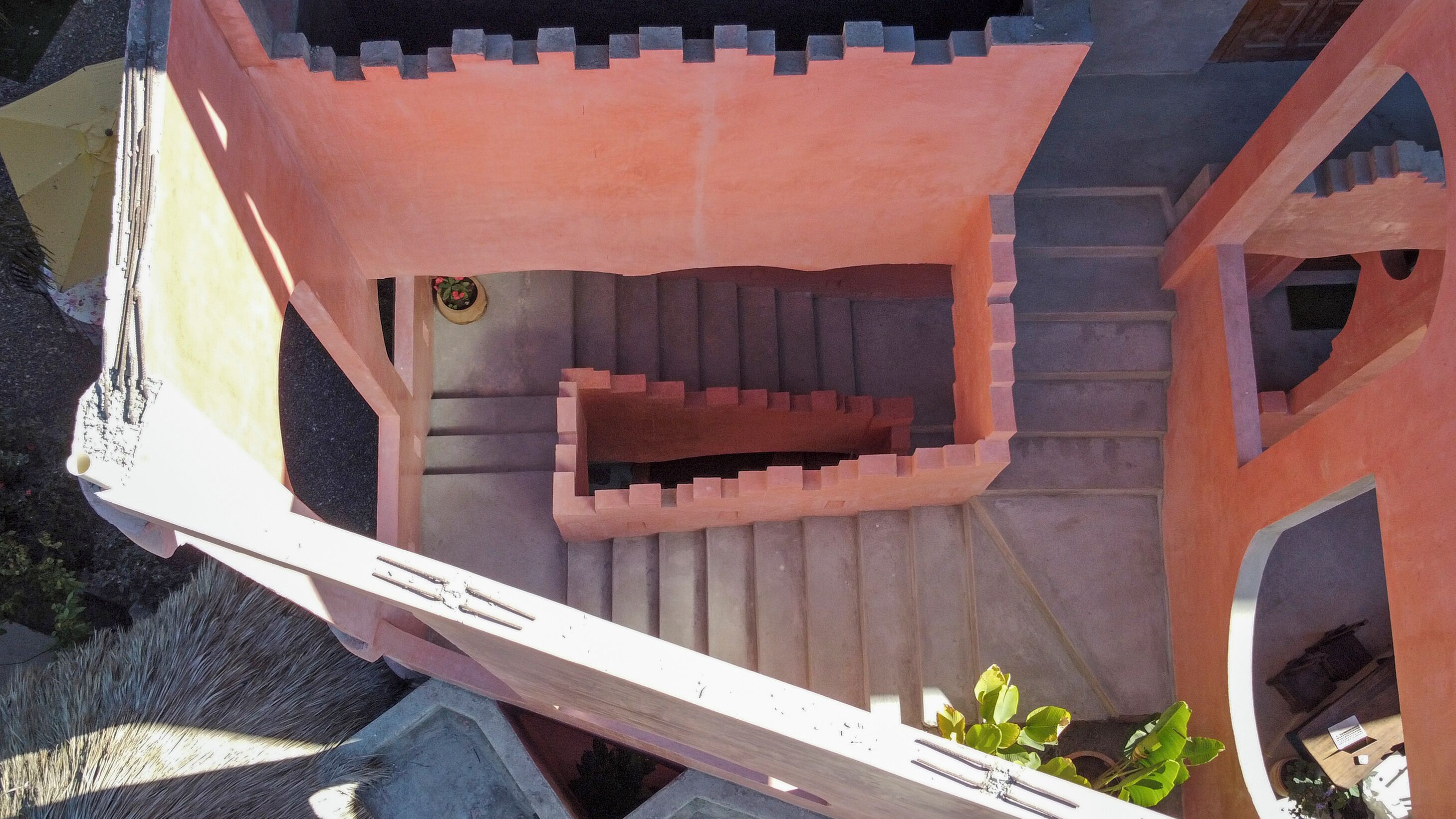 A spiral staircase with a pink and beige color scheme, leading to a higher level.