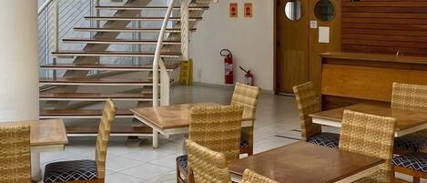 A modern interior with a spiral staircase, wicker furniture, and a wooden reception desk.
