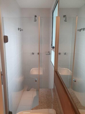 Une salle de bain moderne avec une douche à parois de verre, des toilettes et un lavabo.