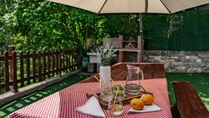 Taula de picnic amb una estovella escacada, una gerra, gots, un quadern i un llemon.