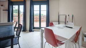 A dining area with a table, chairs, and a view through large windows. - Apartment 'San Miguel Reinante' with Mountain Views, Pool and Wi-Fi (SAN MIGUEL DE REINANTE)