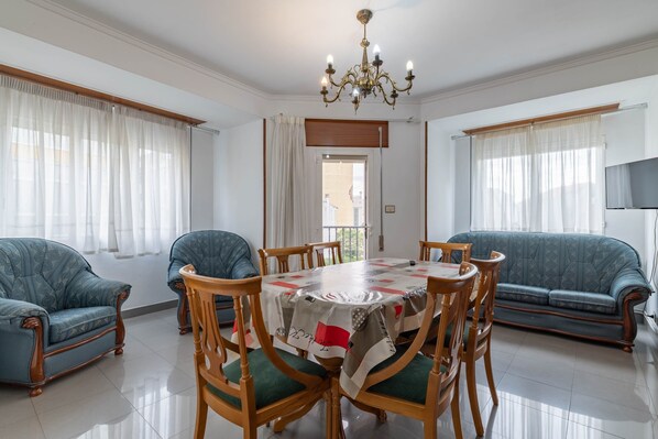 Un comedor con mesa, sillas y un sofá.