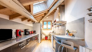 Una cocina moderna con vigas de madera, un ventanal grande y una zona de bar.