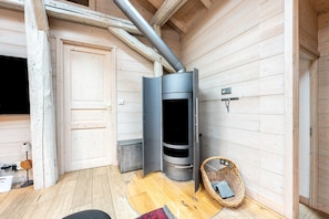 A wooden interior with a modern fireplace, a door, and a wicker basket.