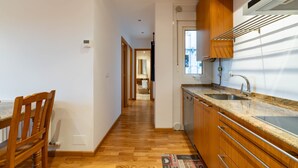 Cocina con gabinetes de madera, encimeras de granito y lavavajillas.