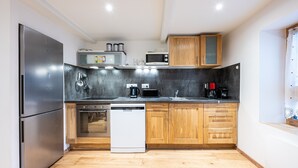 Une cuisine moderne dotée d’appareils électroménagers en acier inoxydable, de meubles en bois et d’un lave-vaisselle.