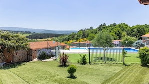 A residential property with a swimming pool, stone walls, and a view of the countryside. - 'Baloco' Apartment with Shared Pool, Terrace, and Wi-Fi (Monforte de Lemos)