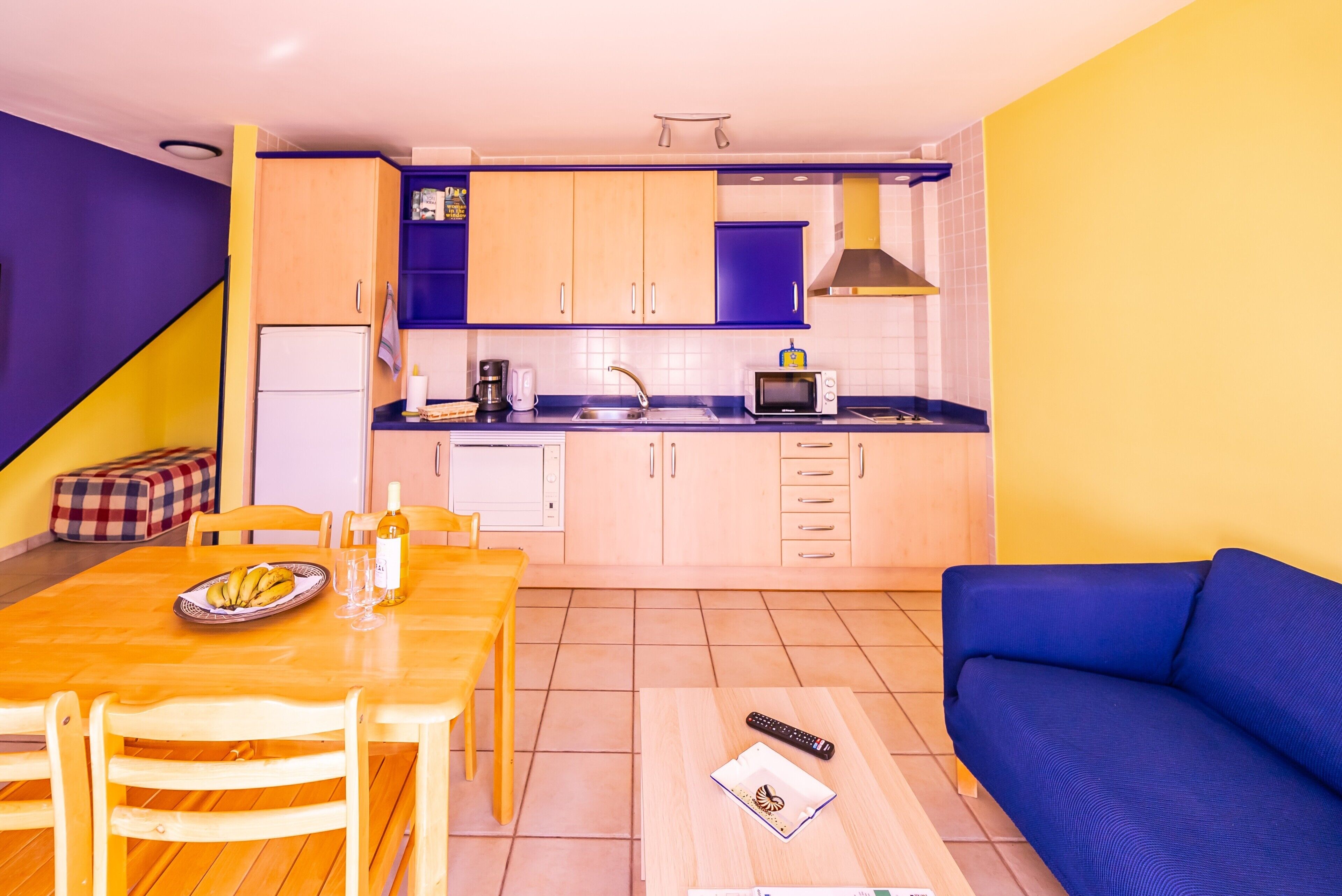 A compact living space with a kitchen, dining area, and a sofa.