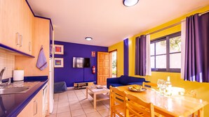 Un espacio habitable compacto con cocina, comedor y zona de estar.