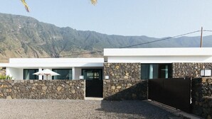Un edifici modern de dos pisos amb façana de pedra, grans finestres i teulada plana.