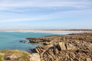 A coastal landscape with rocky terrain and a beach.