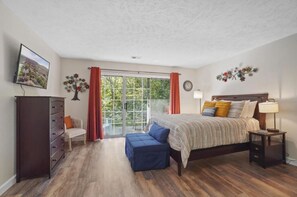 A bedroom with a bed, a dresser, a chair, a small table, and a window with curtains. - Studio Bliss: No Steps, Comfortable & Convenient (Branson)