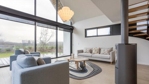 Un salon moderne avec un canapé, une table basse et une cheminée.