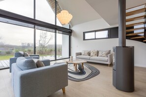 A modern living room with a sofa, coffee table, and a fireplace.